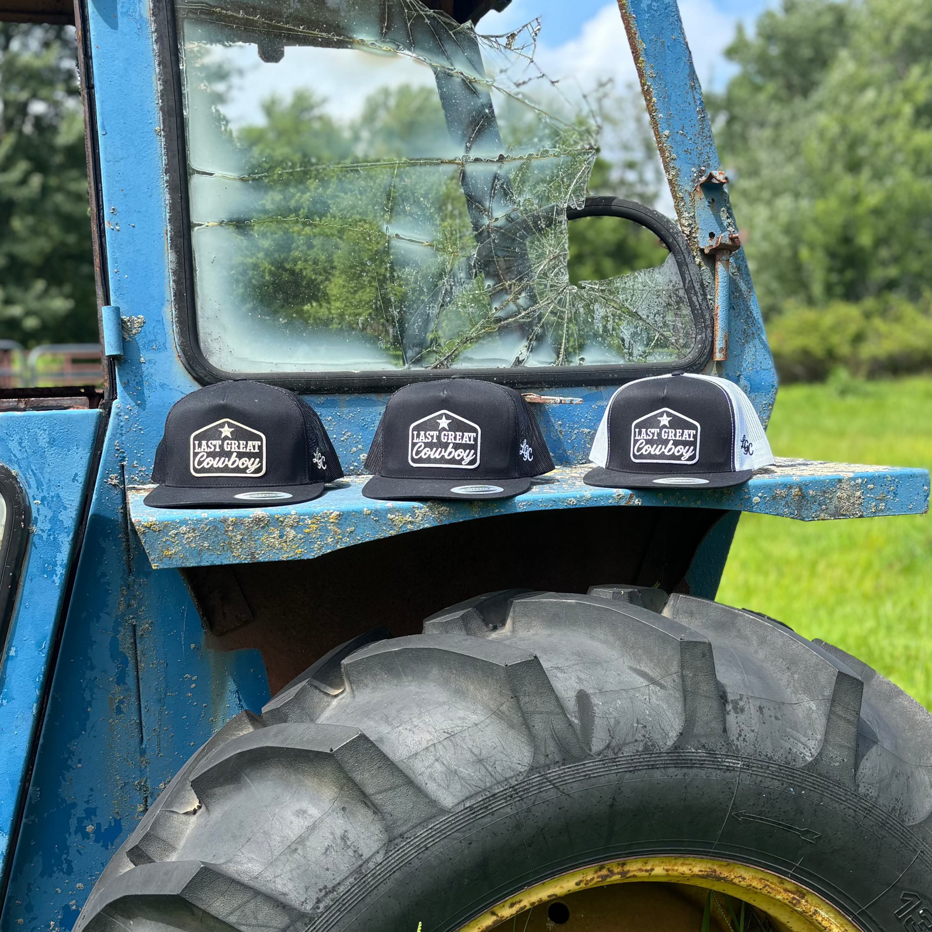 Blue tractor with black hats on a grassy field